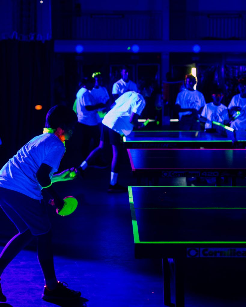 Partie de tennis de table fluo sous lumière UV avec Flu-On